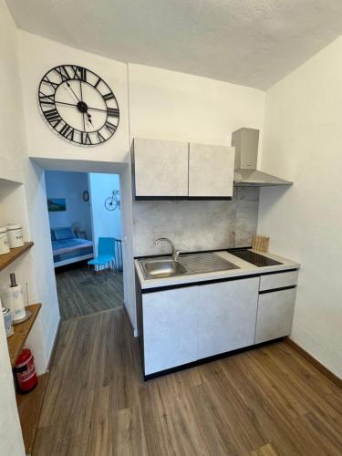 a kitchen with a sink and a clock on the wall at Framari in Vernazza