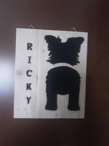 a sign with a black bear hanging on a wall at B&B Il viaggio in Borghesiana 