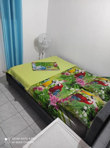 a bed with a colorful blanket on top of it at Espace Nature 97115 in Sainte-Rose