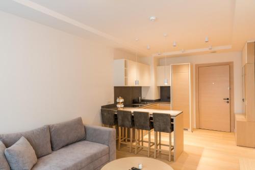 a living room with a couch and a kitchen at Apartmani Zepterme by CENTRAL in Vrnjačka Banja