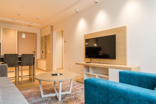 a living room with a couch and a tv and a table at Apartmani Zepterme by CENTRAL in Vrnjačka Banja