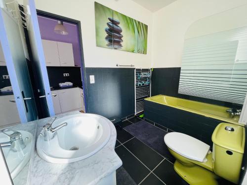 une salle de bain avec un lavabo, des toilettes et une baignoire dans l'établissement F2 Pavot, à La Bourboule