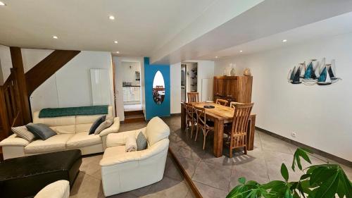 un salon avec un canapé et une salle à manger dans l'établissement Maison de bourg proche de la mer, à Ouistreham