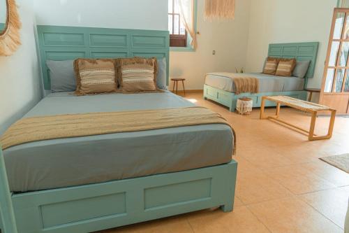 a bedroom with two beds and a bench in it at Hotel Casa Puerta de Mar in Campeche