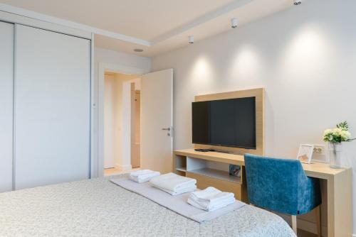 a bedroom with a bed and a desk and a television at Apartmani Zepterme by CENTRAL in Vrnjačka Banja