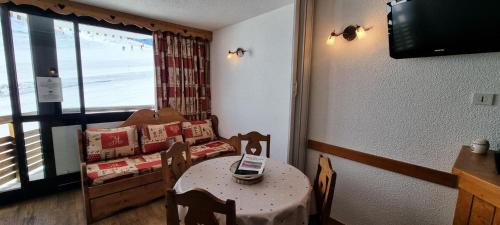 Cette petite chambre comprend une table et un lit avec un téléphone portable. dans l'établissement Résidence Etoile - Studio pour 4 Personnes 194, à La Plagne Tarentaise