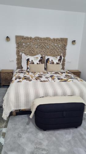 une chambre avec un grand lit avec une tête de lit en bois dans l'établissement Résidence Dica T2, à Port-Saint-Louis-du-Rhône