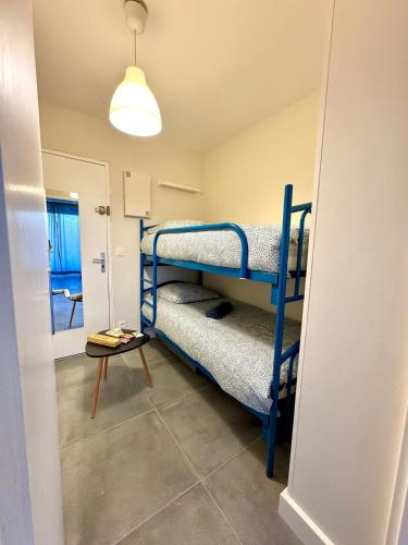 une chambre avec deux lits superposés et une table dans l'établissement LE BLUE PACIFIC- 150m de la plage- Terrasse- Wifi, à La Grande Motte