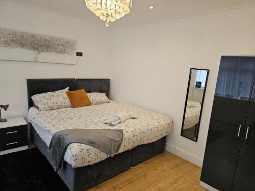 a bedroom with a bed with a mirror and a dresser at jAH LODGE BRSITOL BIG HOUSE STAY FREE PARKING 20 PERCENT OFF WEEKLY MONTHLY STAY BUSINESS CONTRACTOR STUDENTS RELOCATIONS 5BED in Bristol