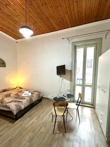 a bedroom with a bed and a table and a chair at Come a casa in Trani