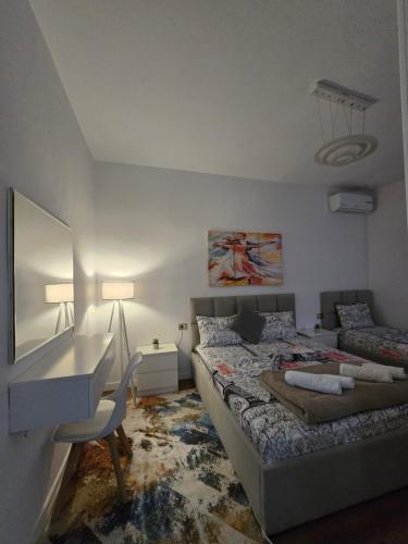 a bedroom with a bed and a desk and a chair at Ideal Home in Shkodër