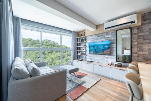 a living room with a couch and a tv at Riviera Verde e Mar 1 dorm by Achei Camboriú in Itajaí