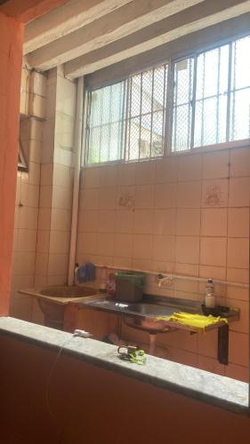 een betegelde keuken met een wastafel en een raam bij Casa da Mãe Maria in Belém