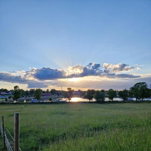 a field with a fence in the middle of a field at Bergs Slussar Glamping in Vreta Kloster