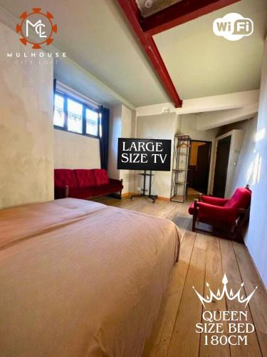 a bedroom with a large sized bed and a red chair at Mulhouse City Loft in Mulhouse