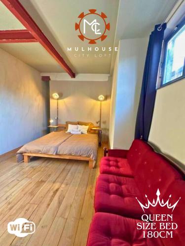 a bedroom with a bed and a red couch at Mulhouse City Loft in Mulhouse