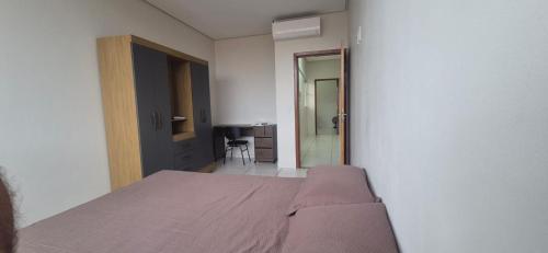 a bedroom with a bed and a door to a bathroom at 201 – APT-Espaço,conforto.È disso que você precisa! in Anápolis