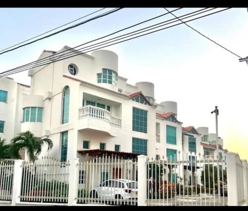 カルタヘナ・デ・インディアスにあるApartaestudio en Condo Privado 100 Mts Playaの白い柵の白い建物