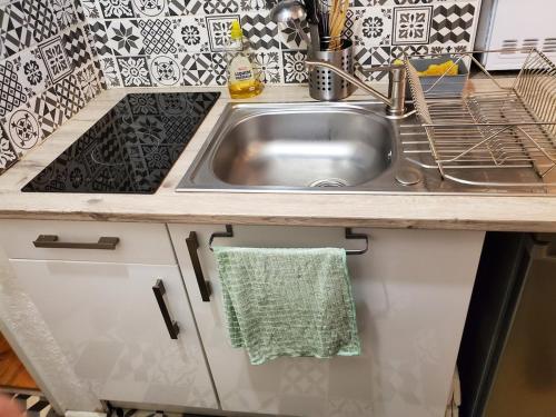 - un évier de cuisine avec une serviette verte suspendue dans l'établissement Super-Besse - studio 800m des pistes, à Besse-et-Saint-Anastaise