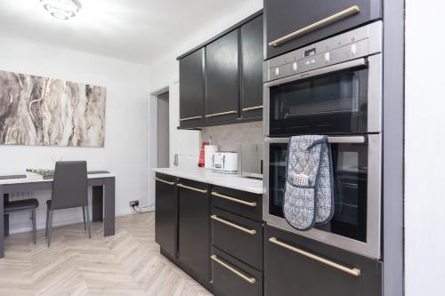 a kitchen with stainless steel appliances and a table at Estwood - Gated House in Southampton
