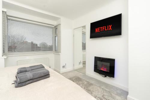 a living room with a tv and a fireplace at Estwood - Gated House in Southampton