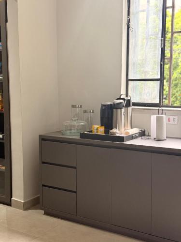 eine Küche mit einer Theke mit einer Kaffeemaschine darauf in der Unterkunft Belô Home & Office in Belo Horizonte