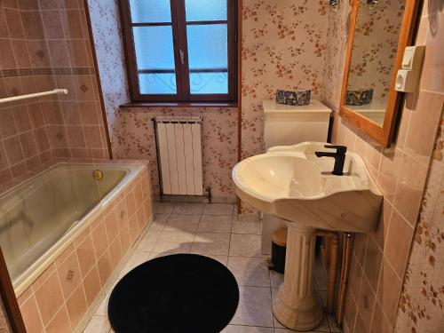 a bathroom with a sink and a tub at Gîte 6 personnes Chez Gaby in Montgreleix