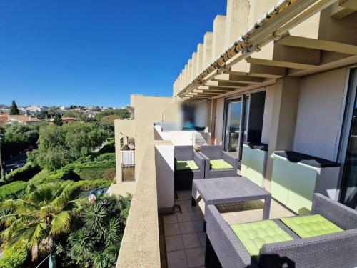 d'un balcon avec des chaises et des tables. dans l'établissement Cozy 1 Br with a seaview, AC, Pool and Parking, à Antibes
