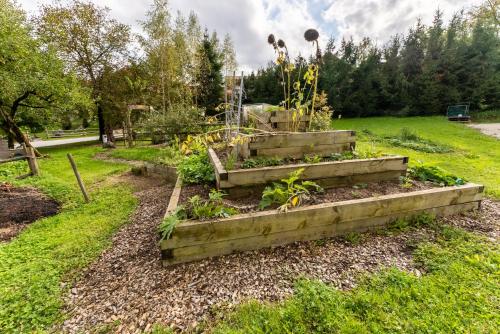a garden with a raised bed in the grass at Korošec Apartments and Wellness Centre in Mozirje