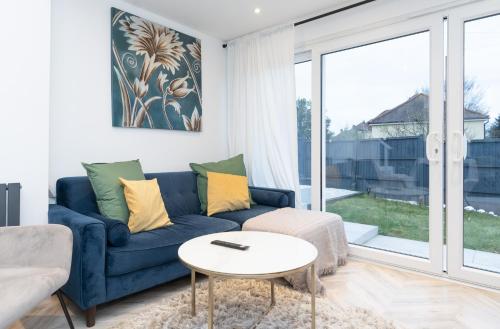 a living room with a blue couch and a table at Estwood - Gated House in Southampton