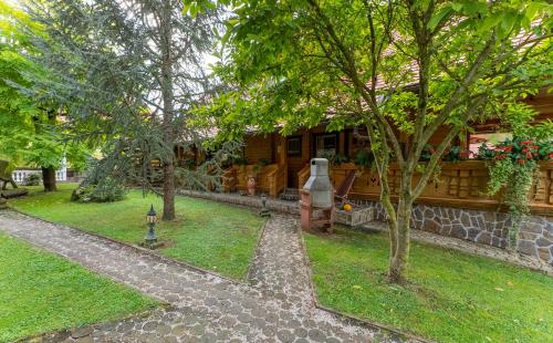 a house with a tree in front of it at Korošec Apartments and Wellness Centre in Mozirje