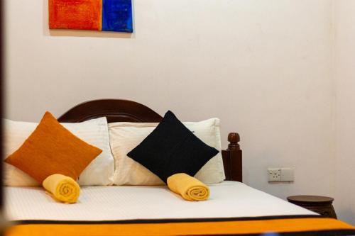 a bed with pillows on top of it at Xotic Resort in Kurunegala