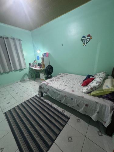 a bedroom with a bed and a table in it at Casa Maravilha in Ananindeua