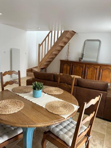 une salle à manger avec une table et des chaises en bois dans l'établissement Maison rénovée en pierres à la campagne, à Pédernec