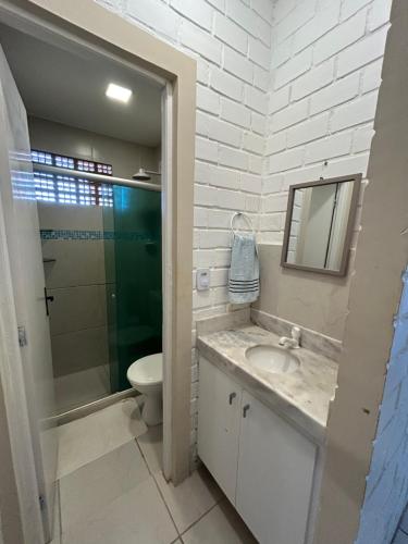 ein Badezimmer mit Waschbecken, Toilette und Spiegel in der Unterkunft Serrambi Paradise in Porto De Galinhas