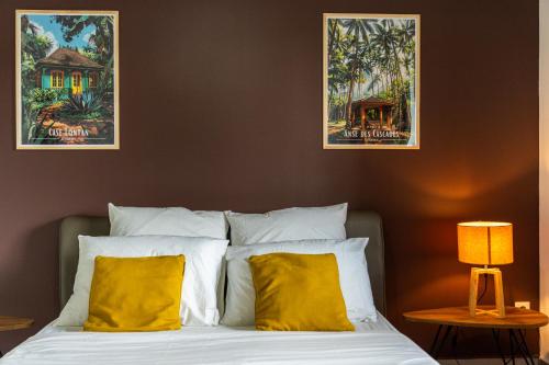 a bedroom with a bed with two posters on the wall at Évasion Créole à Saint-André II - Parking - Clim in Saint-André