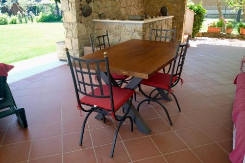 a wooden table and chairs on a patio at Il Melograno - San Quirico d'Orcia in San Quirico dʼOrcia