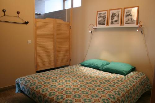 - une chambre avec un lit et des oreillers verts dans l'établissement Calme et tranquillité entre Annecy et Genève, à Vovray-en-Bornes