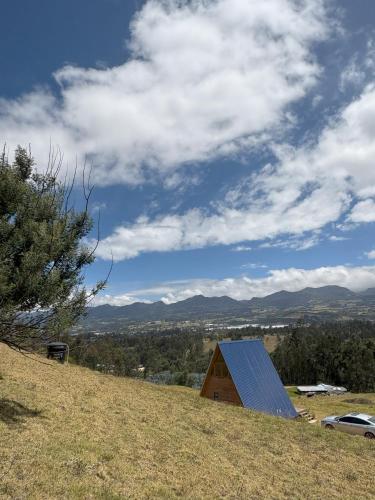 a barn with a solar roof on a hill at La Alejandría de Guasca in Guasca