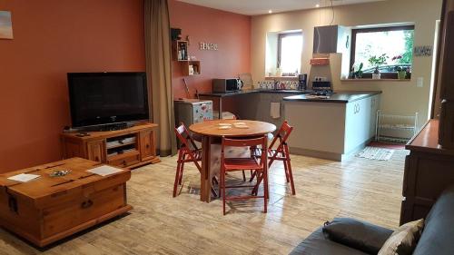 un salon avec une table et une cuisine dans l'établissement Calme et tranquillité entre Annecy et Genève, à Vovray-en-Bornes