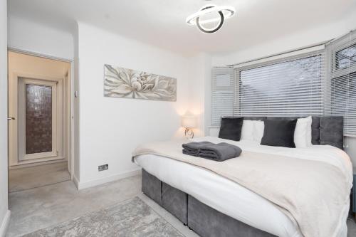 a bedroom with a large bed and a window at Estwood - Gated House in Southampton