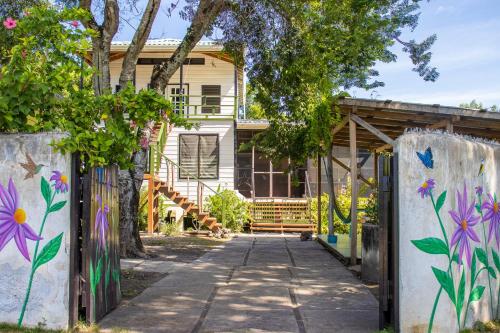 a house with a gate and flowers painted on it at The Retreat at Finca Solana, Corozal, Belize in Corozal