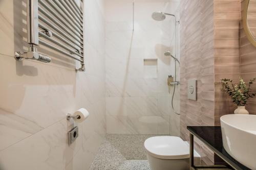 a bathroom with a shower and a toilet and a sink at Colette - LoftAffair Collection in Warsaw