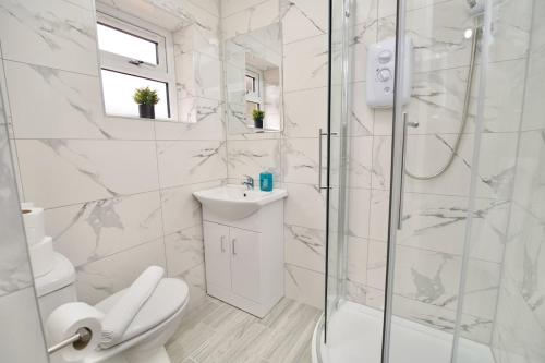 a bathroom with a shower and a toilet and a sink at Monks Villa Fully Furnished Home Coventry in Coventry