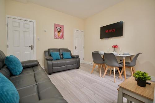 a living room with a couch and a table at Monks Villa Fully Furnished Home Coventry in Coventry