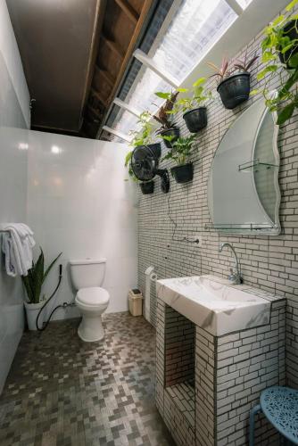 a bathroom with a sink and a toilet and a mirror at Hawaiian Beach House in Legian