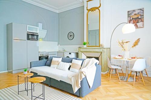 un salon avec un canapé bleu et une table dans l'établissement LeRelaisdOdile1 - Appart Luxe - Idéal Couple & PRO - Hyper Centre - Valenciennes - Tramway - ParkingPossible - Entrée Autonome, à Valenciennes