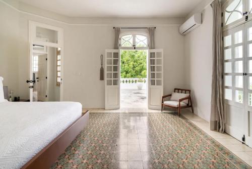 a bedroom with a bed and a window and a chair at Casa Damiana in Mérida