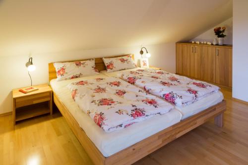 Un dormitorio con una cama grande con flores. en Ferienwohnung Rosalie, en Westerndorf