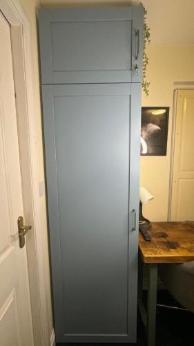 a blue cabinet in a room with a desk at Bedsit Birmingham in Oldbury
